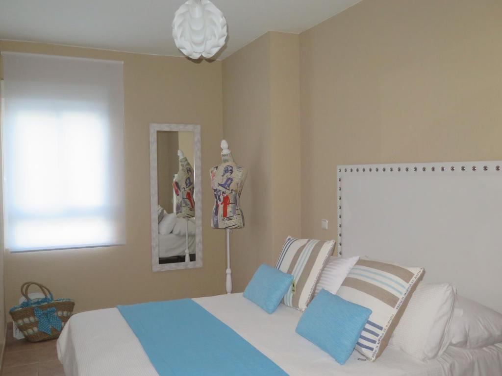 Schlafzimmer mit einem Bett mit blauen und weißen Kissen in der Unterkunft Apartamento Pleno Centro Marbella in Marbella