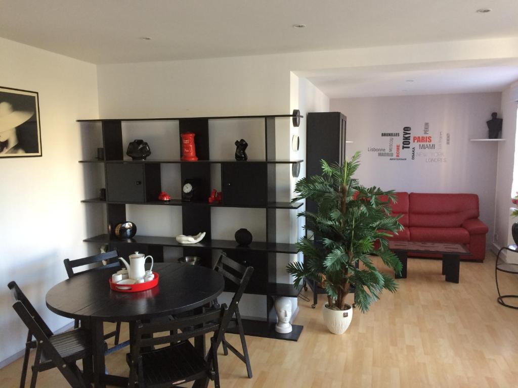 a living room with a table and a red couch at Appartement Granville in Granville