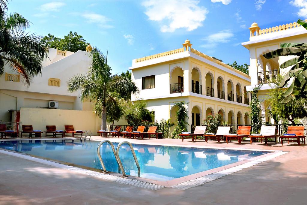 um resort com uma piscina em frente a um edifício em Raj Palace Resort em Sawāi Mādhopur