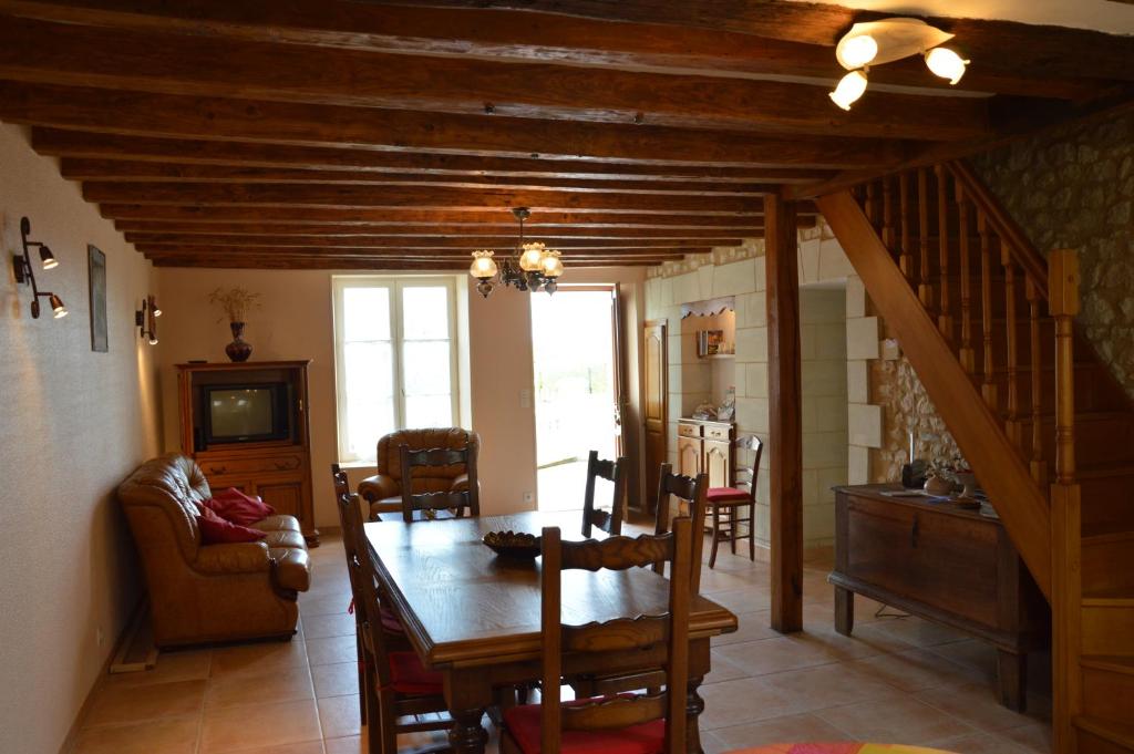 a living room with a dining room table and a dining room at Aux Jardin&#39;s de la Bosniere in Cussay