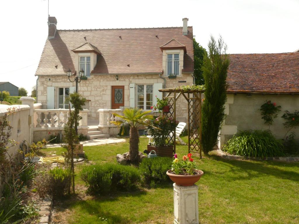 a house with a garden with flowers in the yard at Aux Jardin's de la Bosniere in Cussay