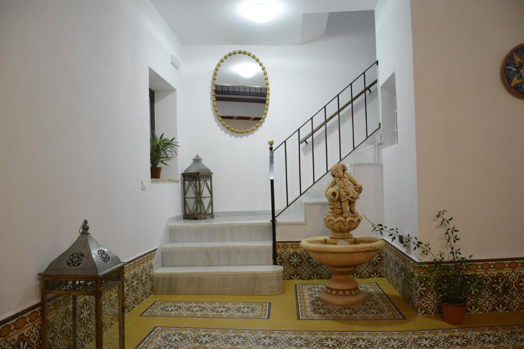 a foyer with a staircase with a statue in the middle at Casa Rural Pueblos Blancos in Bornos