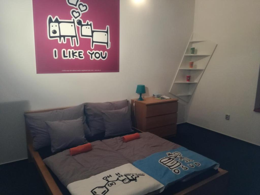 トロヤノヴィツェにあるPenzion UAXのベッドルーム1室(壁に紫の看板が付いたベッド1台付)