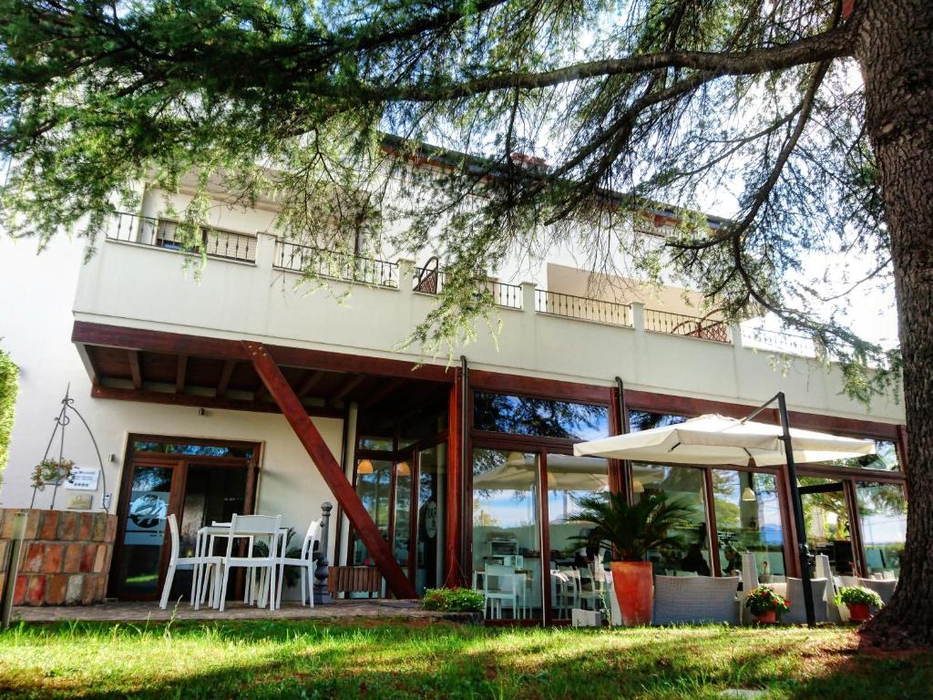 a building with tables and an umbrella in front of it at Boutique Hotel e Spa Città Bianca in Pescara