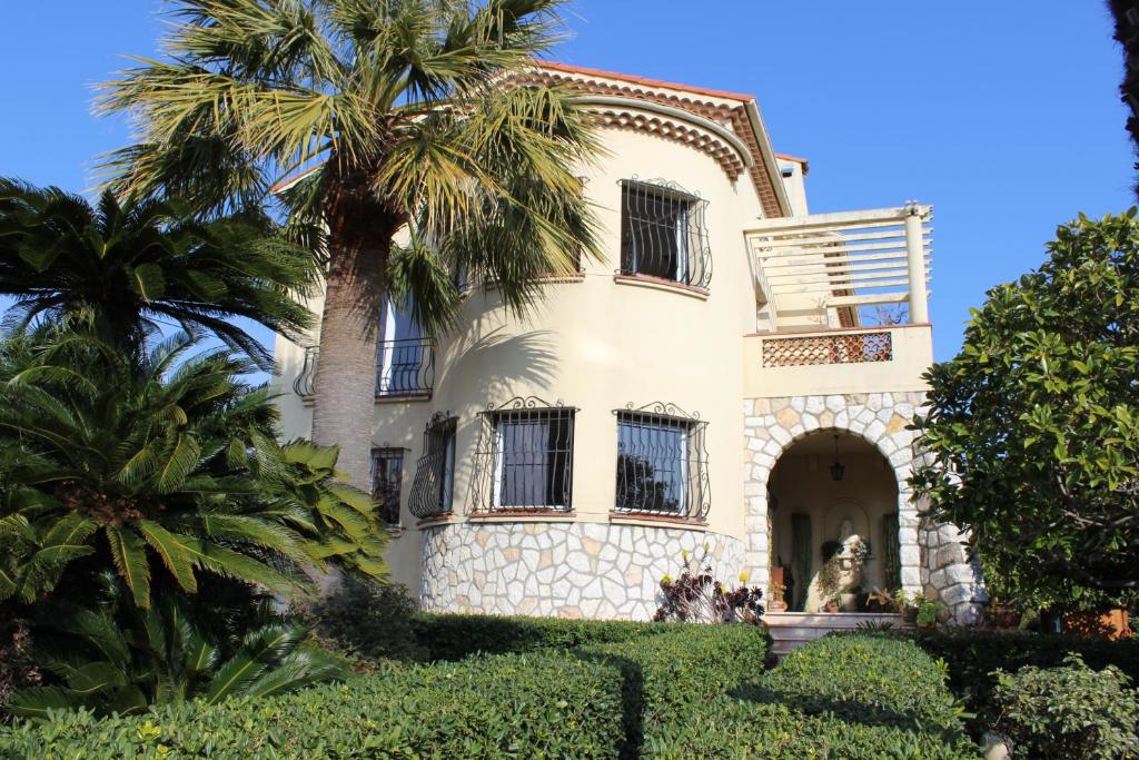 une vieille maison avec un palmier en face dans l'établissement Villa Calliste, à Saint-Laurent-du-Var