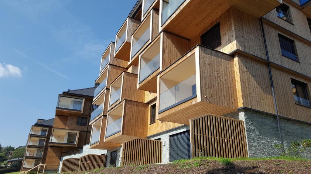 a building with wooden balconies on the side of it at Apartment SCHLADMING - Planai view in Schladming