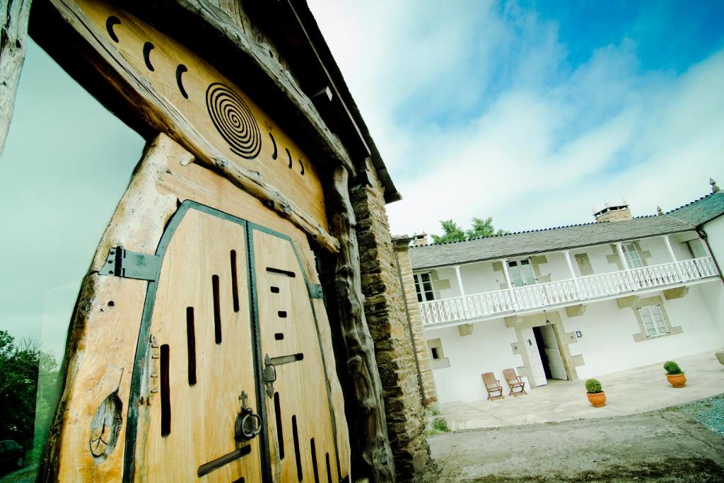 an old wooden door in front of a building at Pazo de Verdes in Cospeito