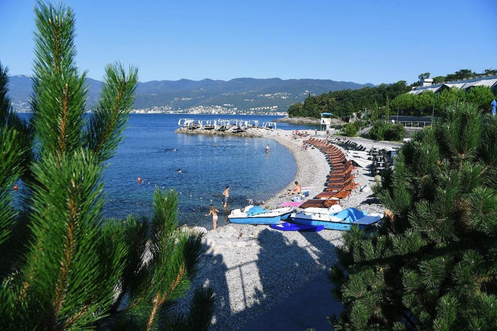una playa con gente y barcos en el agua en Rozata, en Rijeka