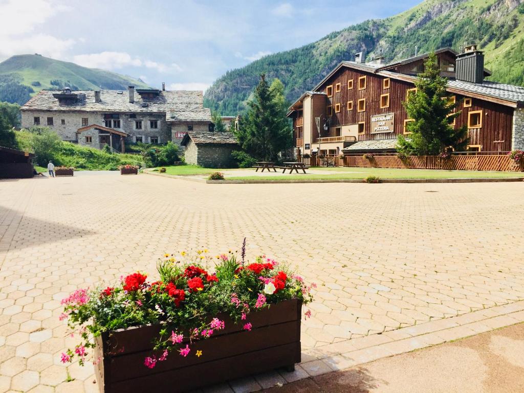 a pot of flowers on a brick courtyard with buildings at Les Balcons de Bellevarde in Val-d'Isère