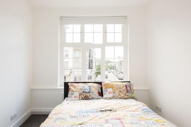 a bed with pillows in a room with a window at Kennington Apartment A/Apartment in London