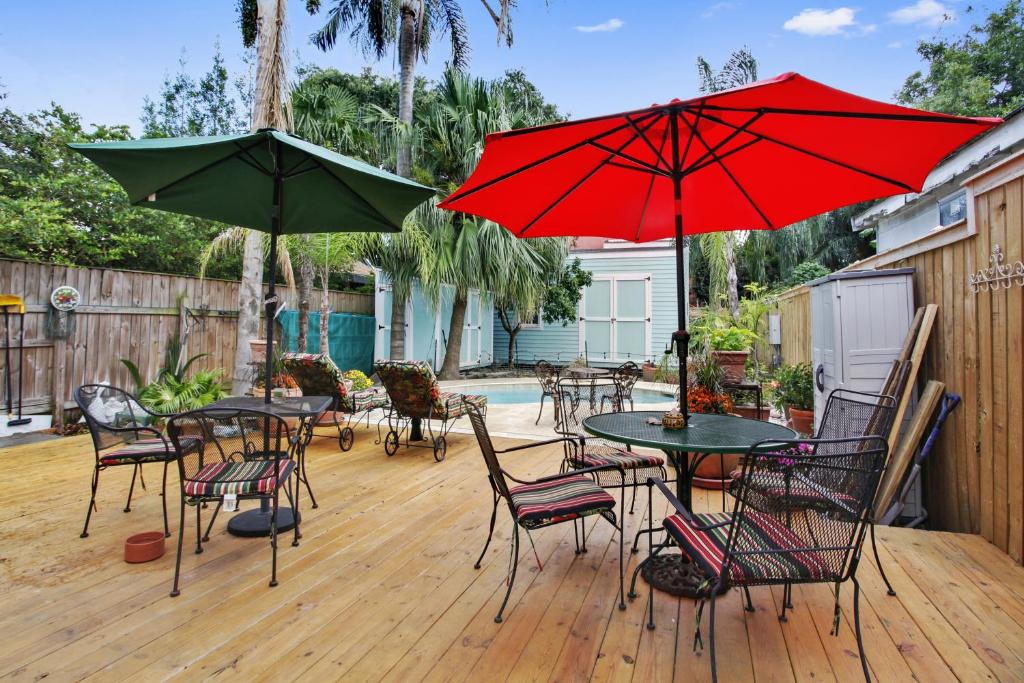 d'une terrasse avec des tables, des chaises et des parasols. dans l'établissement Chez Palmiers B&B, à La Nouvelle-Orléans