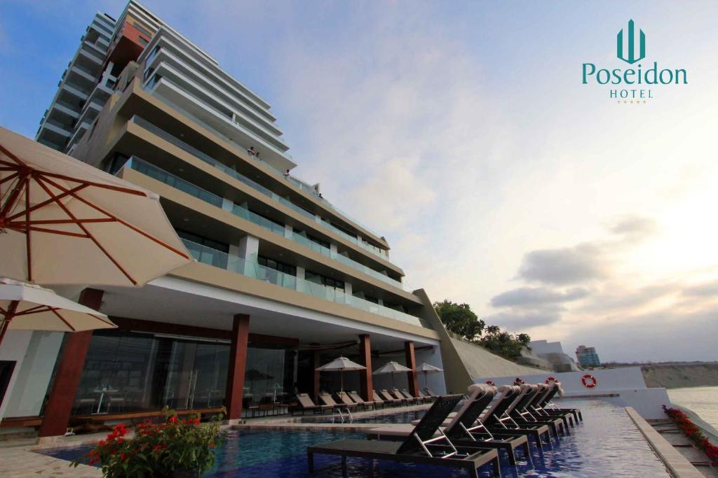 hotel z krzesłami i basen przed nim w obiekcie Hotel Poseidon w mieście Manta