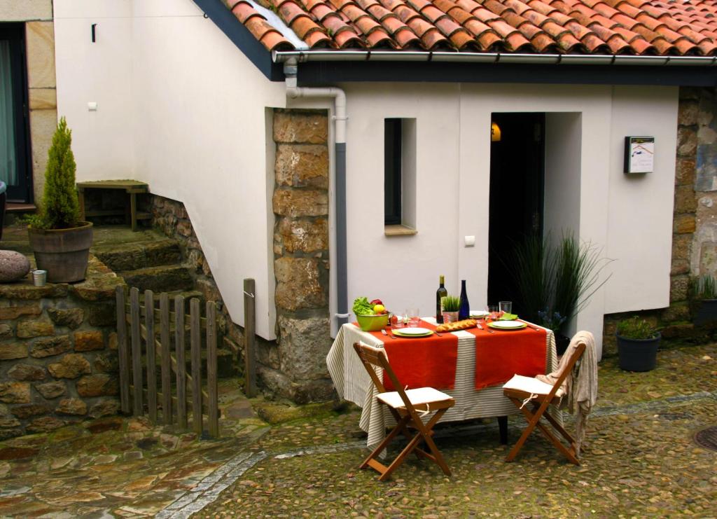 ラストレスにあるCasa rural La Casona del Piqueroの家の前の赤いテーブルクロス付きテーブル