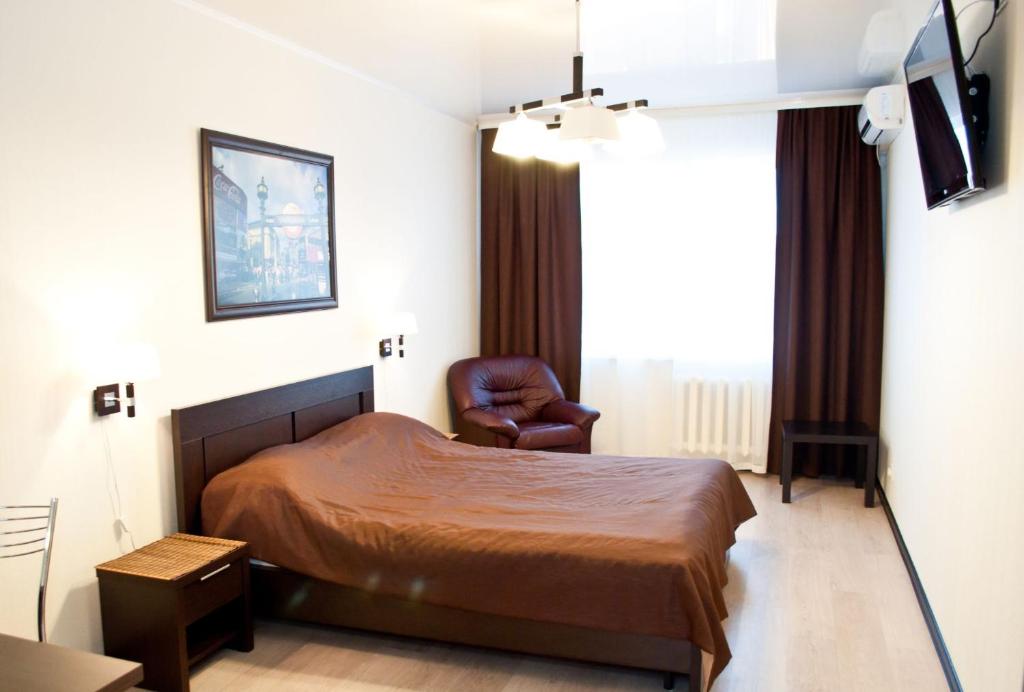 ウファにあるАпартаменты Перовская 38のベッドと椅子付きのホテルルーム