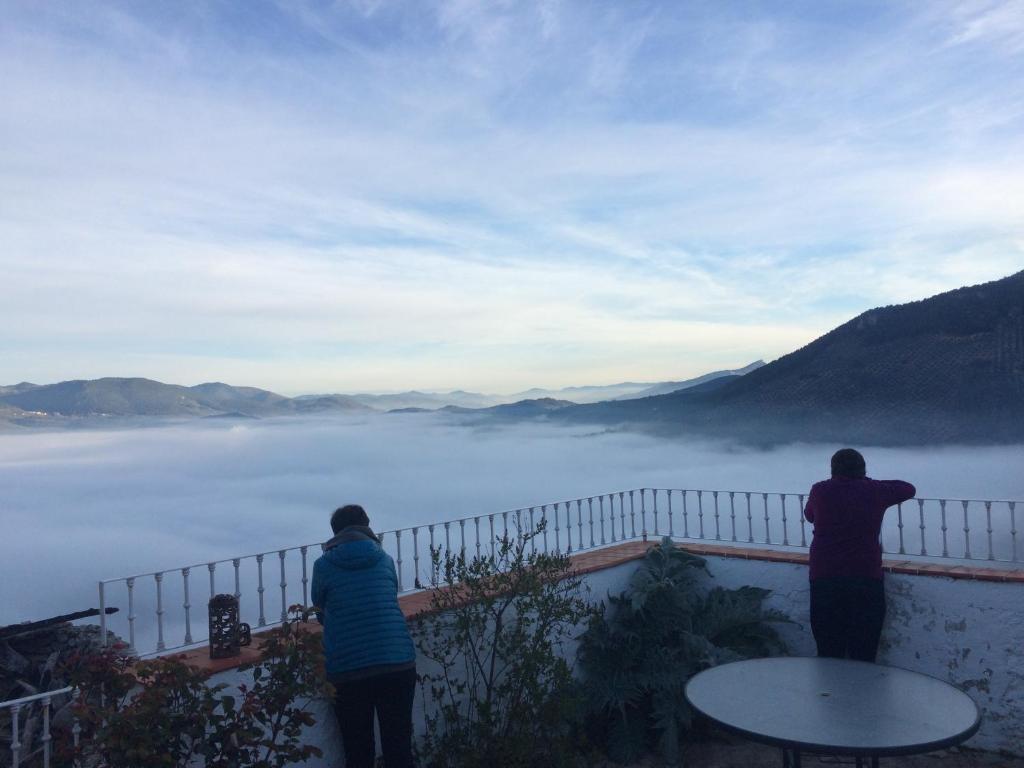 dos personas de pie en una valla mirando a las montañas en Casa El Volaero, en Hornos