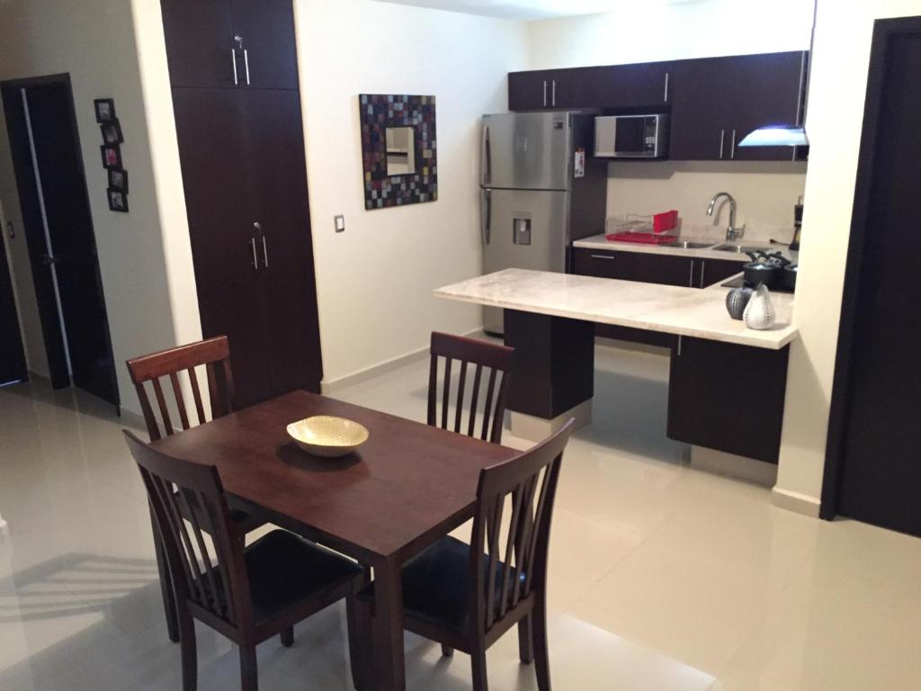 cocina con mesa de madera y sillas en EV Marinos, en Mazatlán