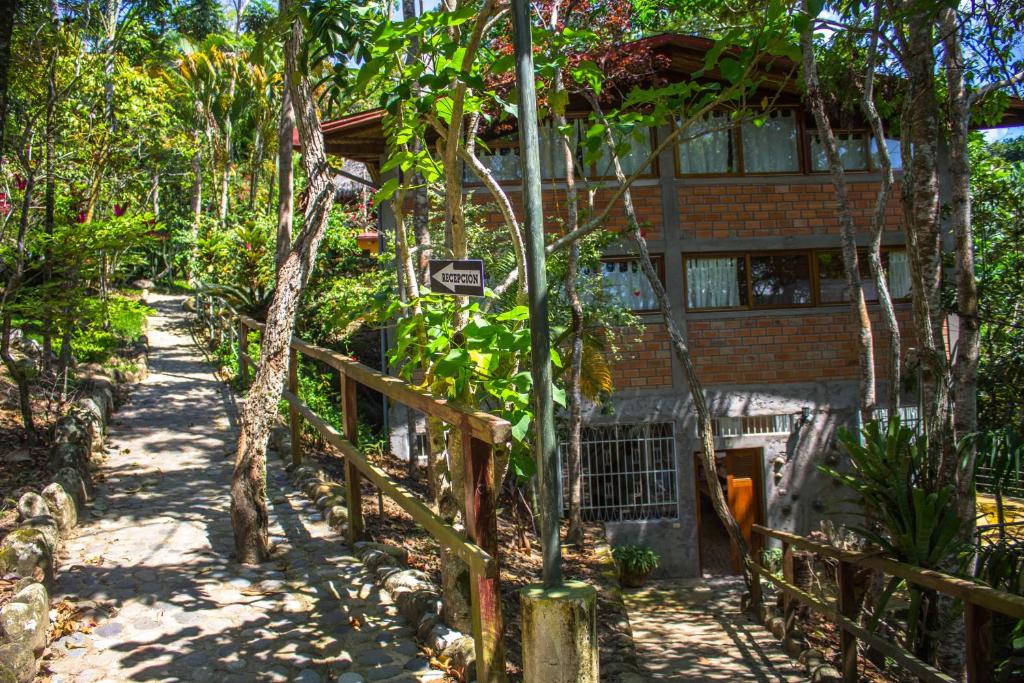 un bâtiment avec une clôture et des arbres devant lui dans l'établissement Yacumaman Sanctuary, à Tarapoto