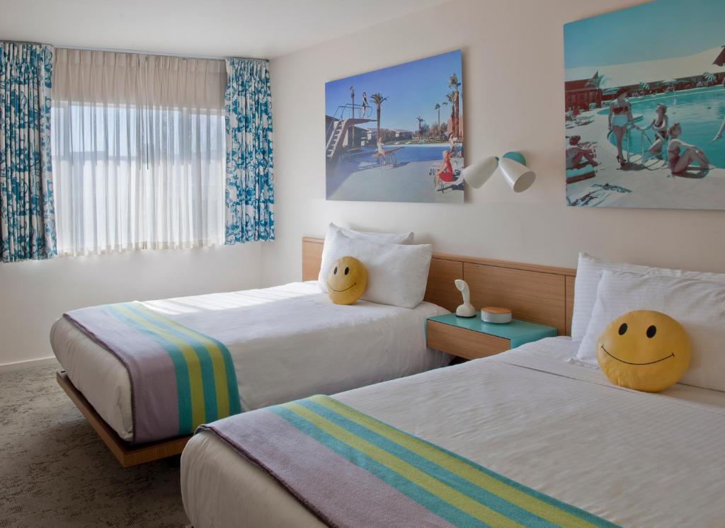una habitación de hotel con 2 camas con caras en Beverly Laurel Hotel, en Los Ángeles