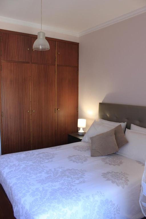 1 dormitorio con 1 cama grande y armarios de madera en Flamingo Rose, en Oporto