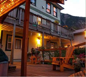 ein Haus mit einer Terrasse und einem Stuhl auf einer Veranda in der Unterkunft Alaska's Capital Inn Bed and Breakfast in Juneau