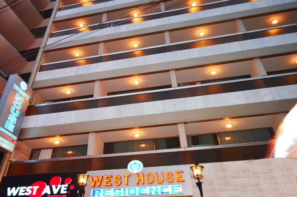 a building with a west house restaurant sign in front of it at West House Residence in Beirut