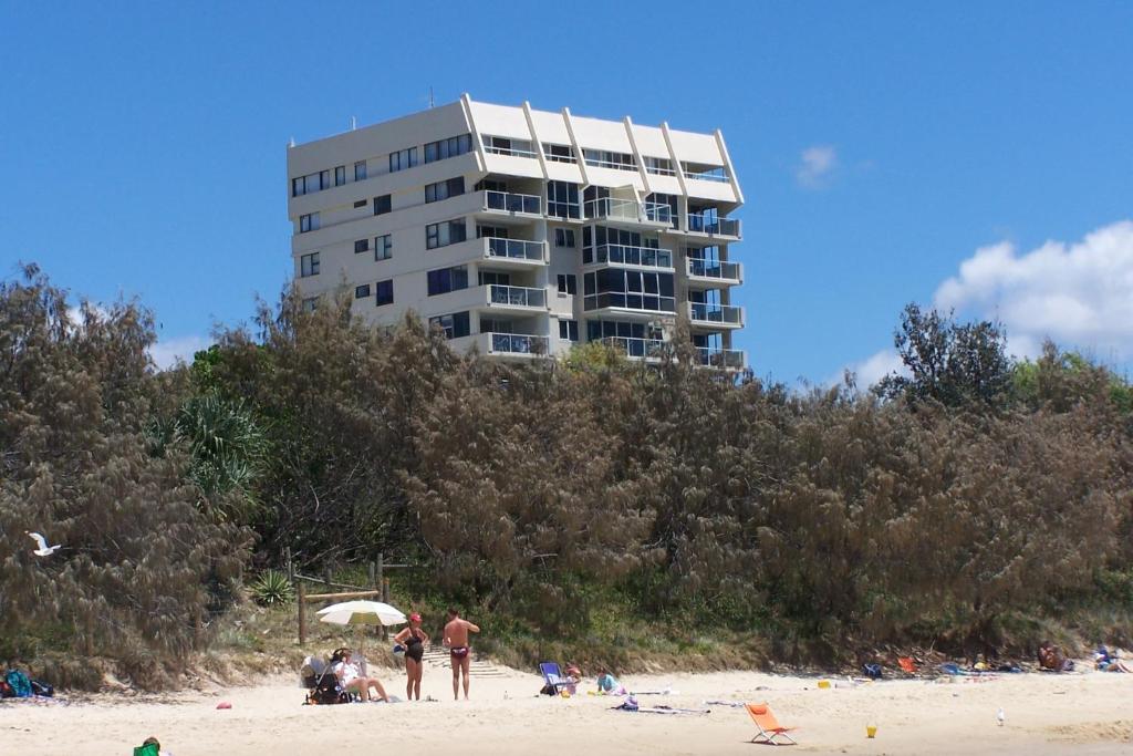 a building on the beach with people on the beach at 84 The Spit Holiday Apartments in Mooloolaba