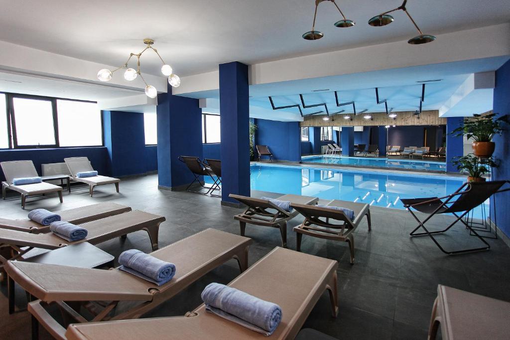 una piscina con mesas y sillas junto a ella en L.M Club Hotel en Tiflis