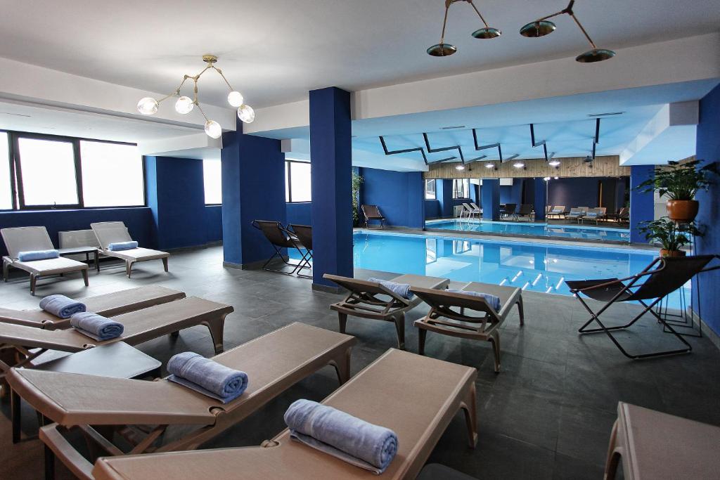 a swimming pool with tables and chairs next to it at L.M Club Hotel in Tbilisi City