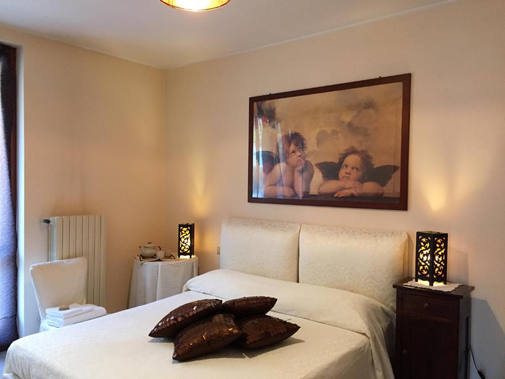 a bedroom with a bed with a painting on the wall at Casa delle Magnolie in Cassina deʼ Pecchi