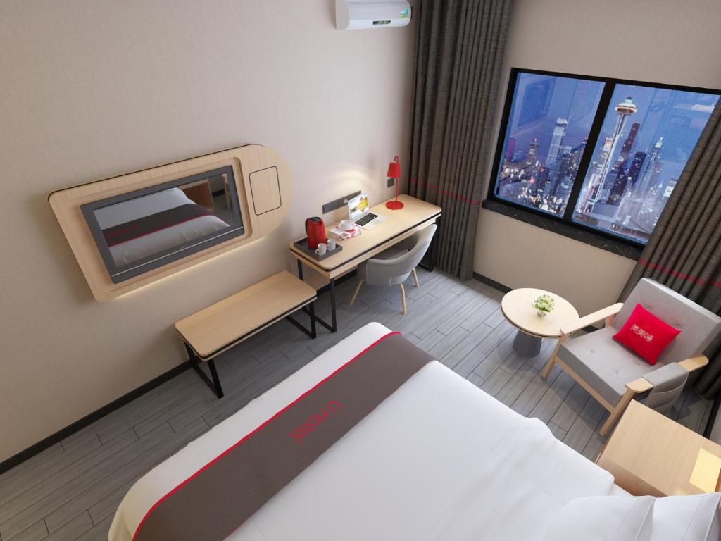 a small hotel room with a bed and a desk at Thank Inn Chain Hotel Tianjin Meijiang Exhibition Center in Tianjin