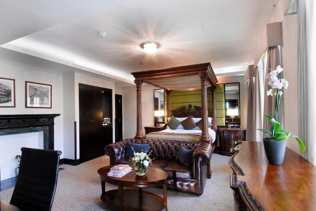 a bedroom with a bed and a couch and a table at Montcalm Brewery, London City in London