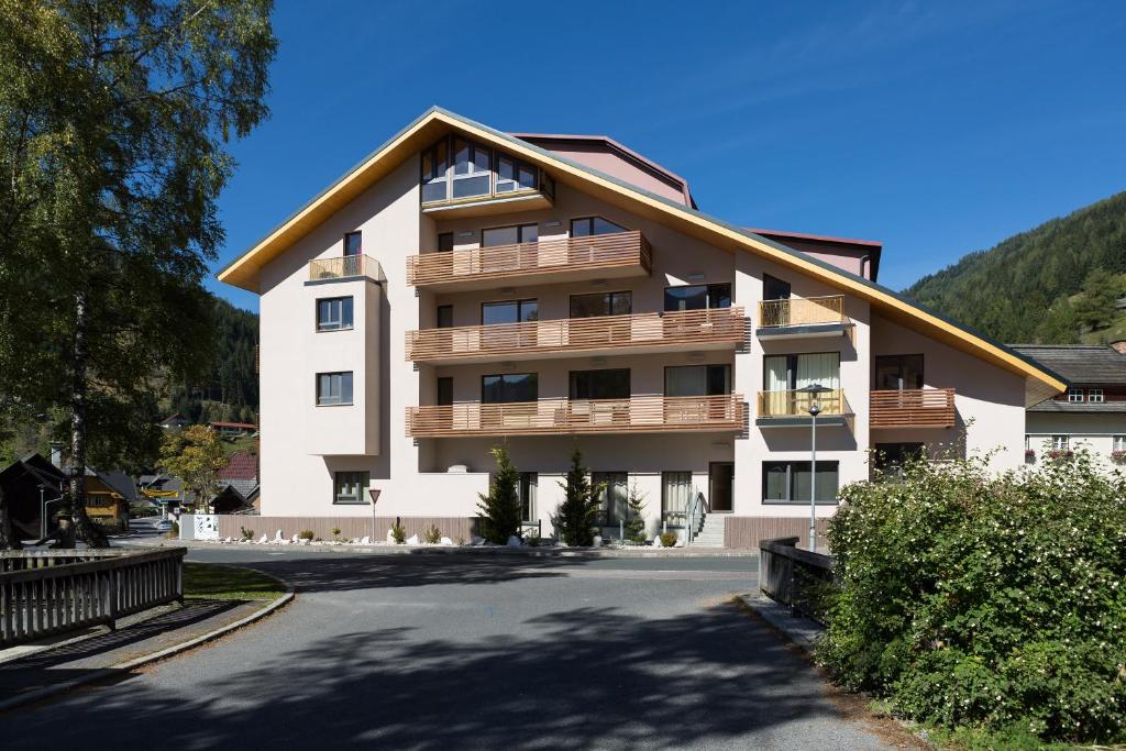 un gran edificio de apartamentos con balcones en una calle en Quercus Appartements contactless check-in en Patergassen