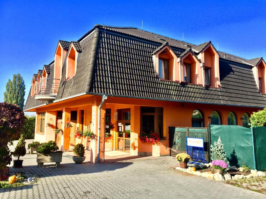 a large orange house with a black roof at Hotel Senica, Garni in Senica