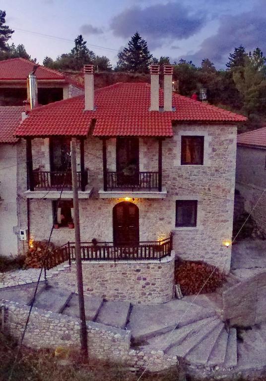 a large stone house with a red roof at Thea Valtessinikou in Valtessiniko