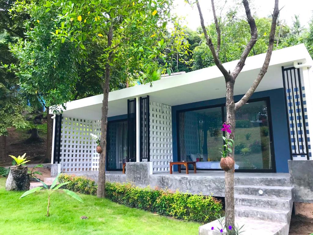 a small house in a yard with trees at Kiri Tawan in Baan Tai