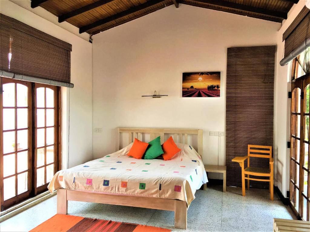 a bedroom with a bed with orange and green pillows at Dolce Casa in Colombo