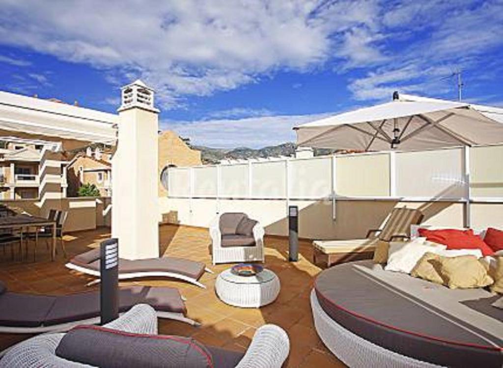 ベナルマデナにあるApartamento Estrella del Mar 100m de la playa 2 terrazas garageのパティオ(椅子、パラソル付)