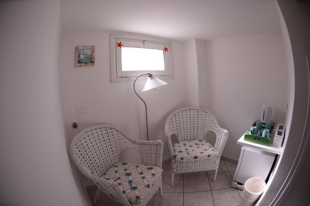 a living room with two chairs and a lamp at La Divina in Muggiano