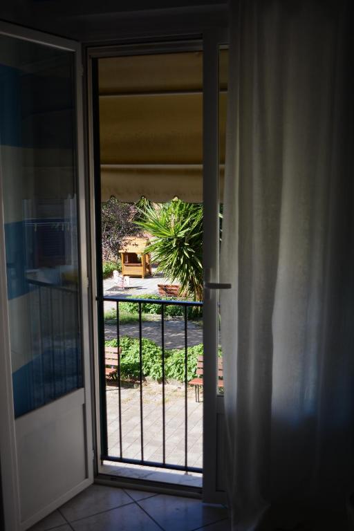 an open door with a view of a yard at La Divina in Muggiano