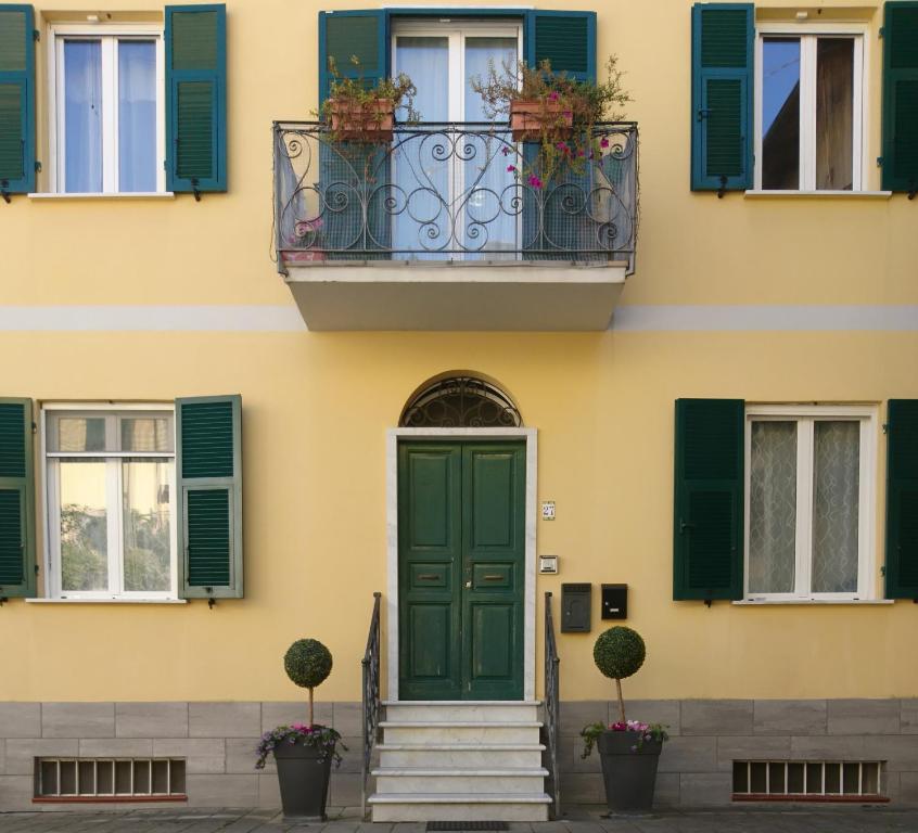 a building with a green door and a balcony at La Divina in Muggiano