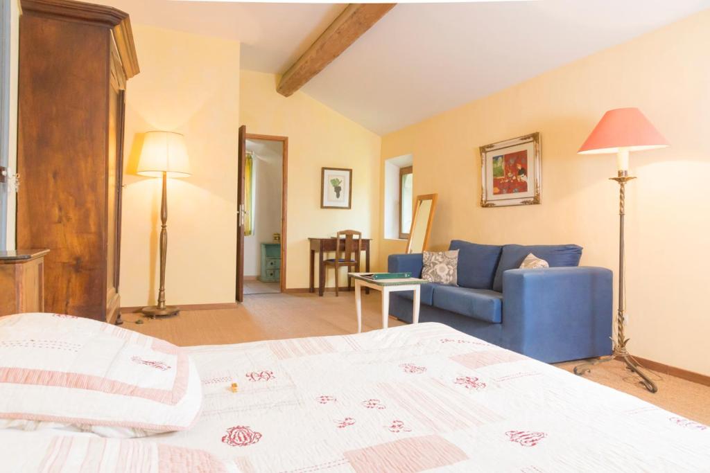 Cascastel-des-CorbièresにあるDomaine Grand Guilhemのベッドルーム(ベッド1台、青いソファ付)