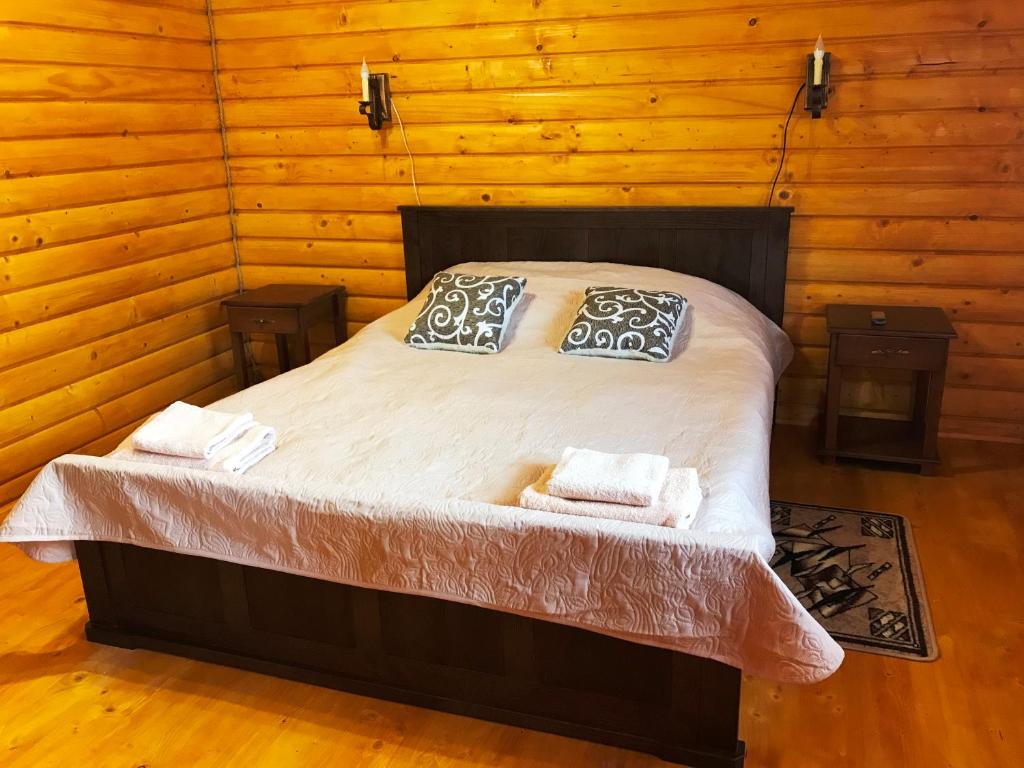 um quarto com uma cama num quarto de madeira em Guest House U Stasuka em Vorokhta