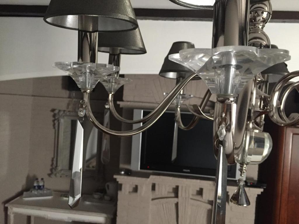 a metal chandelier with two lamps and a tv at The Tudor Hotel in Harrow