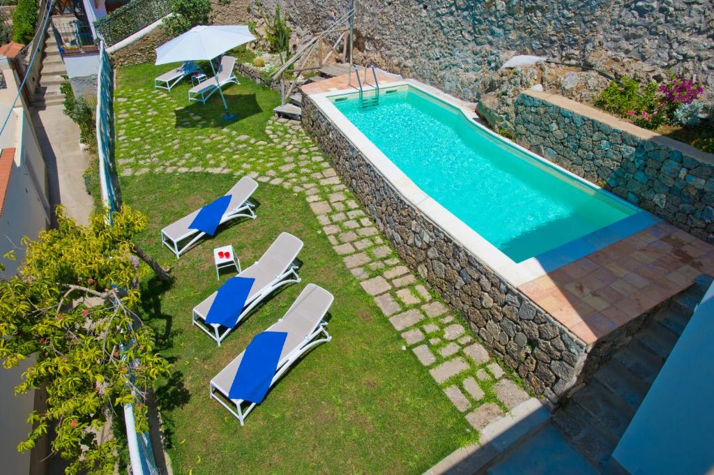 an overhead view of a swimming pool with lounge chairs and a swimming pool at Villa Imperati in Praiano