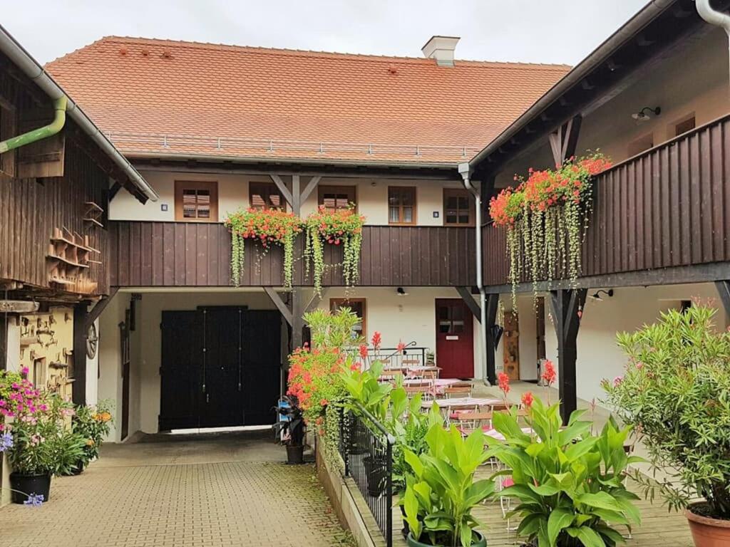 a building with tables and flowers in front of it at Zum Egerländer Fachwerkhof in Neualbenreuth