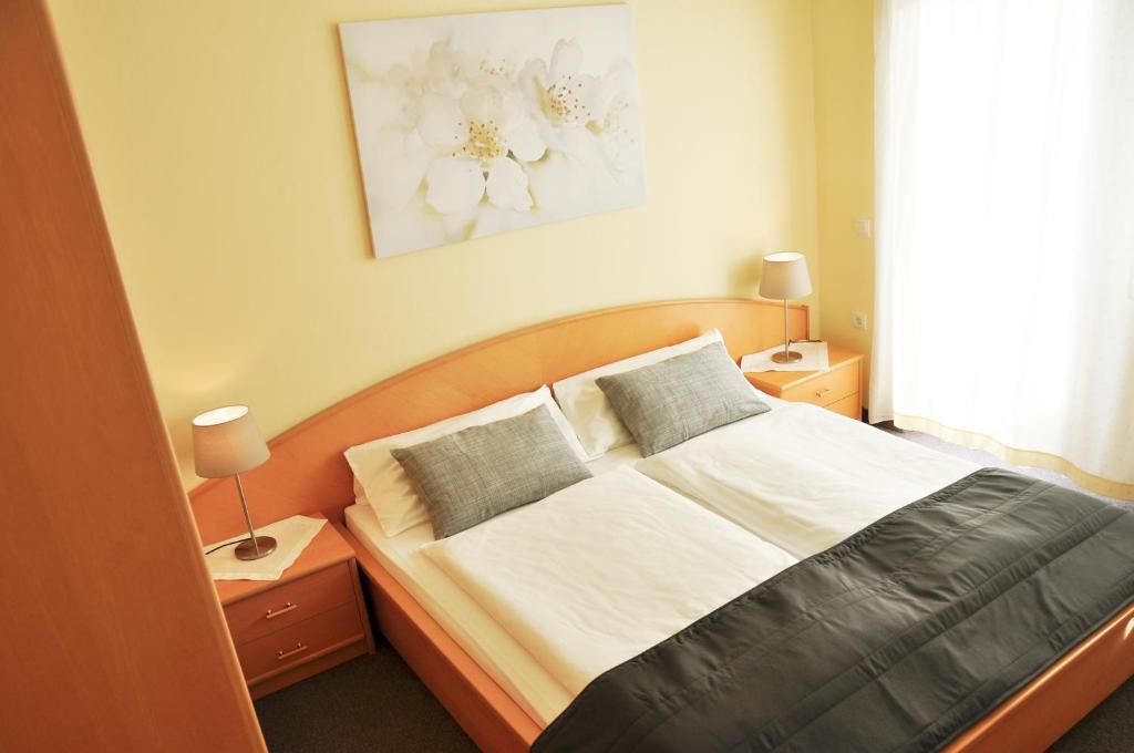 1 dormitorio con 1 cama con 2 almohadas en Gästehaus Hofer, en Gumpoldskirchen