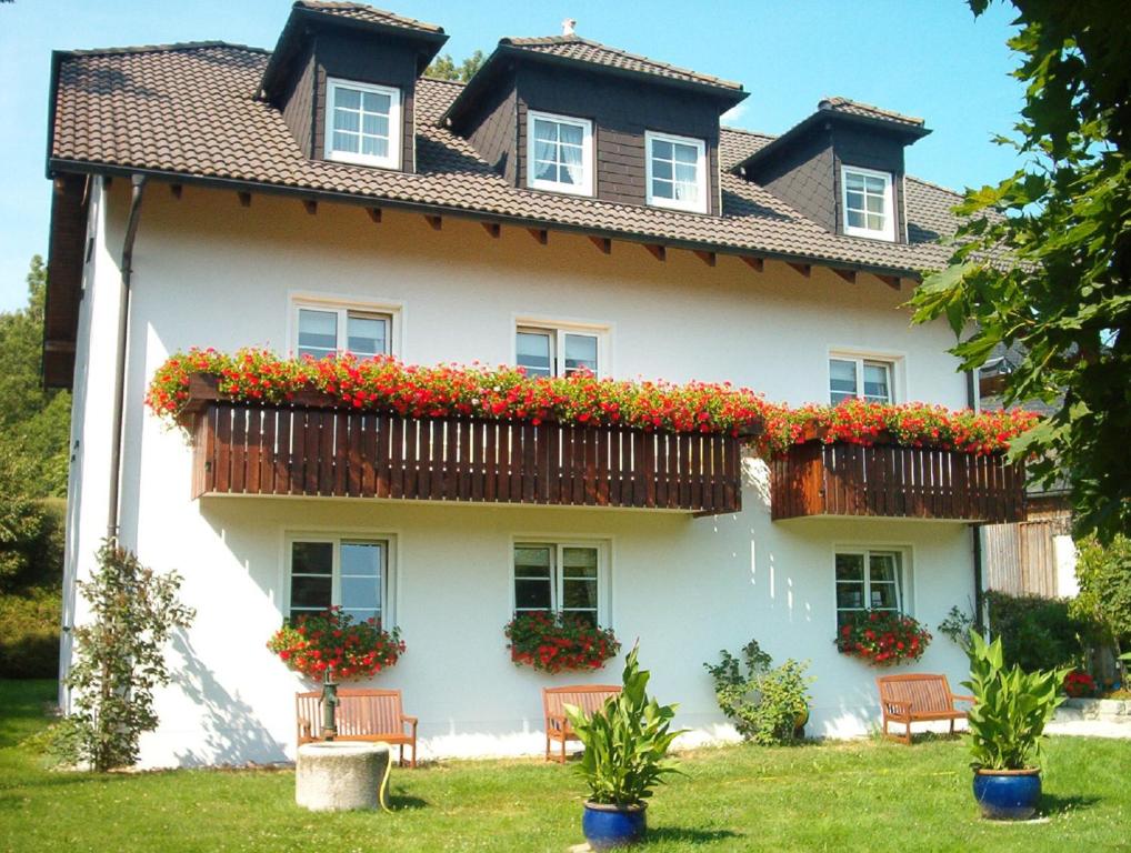 a large white house with flowers on the balcony at Gasthof Pension Walther in Weißdorf