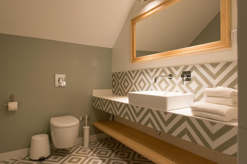 a bathroom with a sink and a mirror and a toilet at Smokvica Dorćol B&B in Belgrade