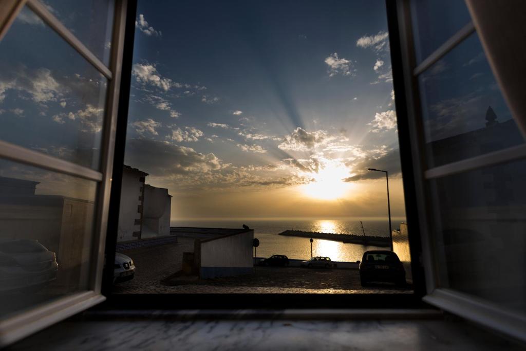 a view of the sunset from a window at Ericeira Soul Guesthouse in Ericeira