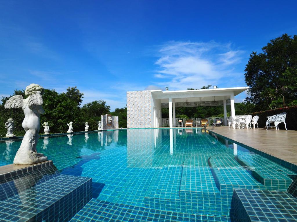 a large swimming pool with a building in the background at Baan Ing Khao in Pak Chong